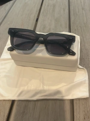 Svarta solglasögon från Chimi 04 - Snygga svarta solglasögon från Chimi med rektangulär form och mörka glas. Bågarna är tillverkade i syntetmaterial och har en stilren, modern look som passar perfekt till sommaren. Utan box