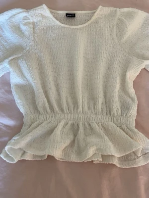 Vit blus med volang och puffärm💓 - Superfin vit blus från Gina Tricot med puffärmar och volang nertill. Toppen har resår i midjan och är ifrån Gina tricot i storlek xxs💓