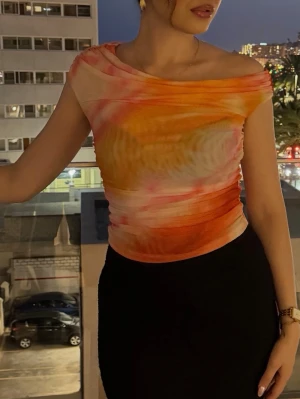 Orange Färgglad offshoulder topp i mesh -  Offshoulder topp i mesh med swirlmönster. Använd en gång bara. 