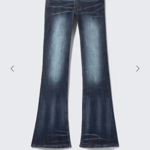 cheap monday jeans  - Snygga mörkblå jeans med bootcut passform och coola slitningar på låren och knäna. Jeansen har en klassisk femficksdesign och är tillverkade i ett robust denimtyg som ger en autentisk känsla. Perfekta för dig som gillar en retroinspirerad look. OBS! Jag har sprätt upp dem där nere