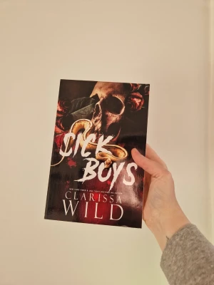 Sick Boys av Clarissa Wild - En mörk och spännande skönlitterär bok med titeln 'Sick Boys' av Clarissa Wild. Omslaget är svart med röda och guldiga detaljer, inklusive en dödskalle och rosor. Perfekt för dig som gillar dramatik och mystik i bokform. Helt ny men har några mindre defekter som var där när jag köpte den. Nypris 257 kronor