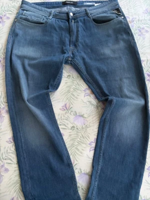 Blå jeans från Replay - Snygga blå jeans från Replay med klassisk femficksdesign och raka ben. Jeansen har en lätt tvättad look och är tillverkade i mjukt denimtyg. Perfekta för en avslappnad och trendig stil. Pris kan diskuteras vid snabb affär