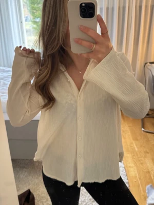 Vit oversize skjorta med vida ärmar - Vit strukturerad skjorta i oversize-modell med långa, vida ärmar. Den är i mycket bra skick och endast använd fåtal gånger.