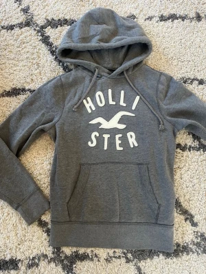 Grå hoodie från Hollister - Snygg grå hoodie från Hollister. Super mjukt material och bra för en ren look. Skriv för mer bilder eller info, pris kan diskuteras! 🌊