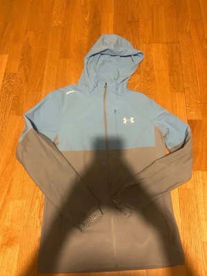 Ljusblå och Grå Under Armour jacka - Inga fel på den alls och väldigt bra pris. Skriv om du har några frågor priset kan diskuteras.