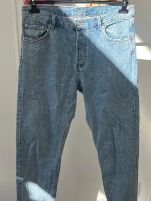 Blå Barrel jeans, Relaxed från Weekday W32/L32 - Säljer ett par klassiska blå Barrel jeans från Weekday. De har en avslappnad passform med hög midja och raka ben. Jeansen är tillverkade i bomull och har fem fickor samt knappgylf. Perfekta för en chill och stilren look.