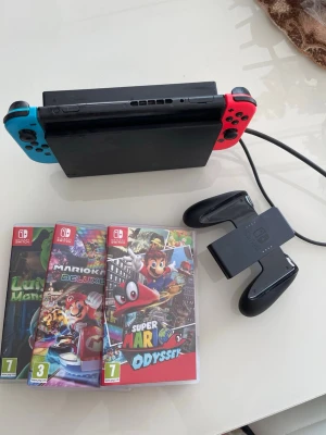 Nintendo Switch med spel och tillbehör - Nintendo Switch med blå och röd Joy-Con, dockningsstation och handkontrollshållare. Inkluderar fem populära spel: Luigi's Mansion 3, Super Smash Bros Ultimate, Minecraft, Mario Kart 8 Deluxe och Super Mario Odyssey. Perfekt för gaming och multiplayer. Kan diskutera priset 