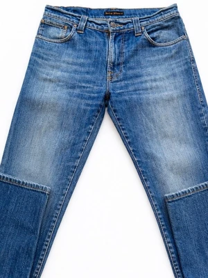 Blå raka jeans från Nudie Jeans - Säljer ett par klassiska blå jeans från Nudie Jeans med rak passform och fem fickor. Jeansen har snygga slitningar och kontrastsömmar, samt Nudie-logga på bakfickan. Tillverkade i bomullsdenim och perfekta för en avslappnad stil. Storlek w33 och L34 men sitter lite litet i midjan, jag känner de som 30-32