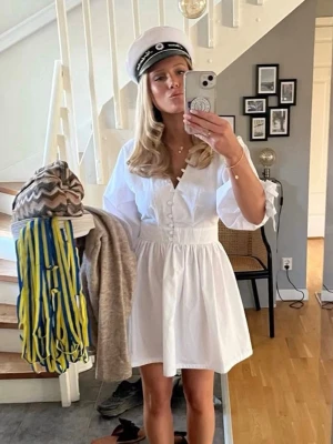 Studentklänning - En jättefin och trendig klänning som är perfekt för t.ex student eller skolavslutning✨. Den är vit, kort, har puffärmar och knappar framtill. Klänningen är slutsåld på hemsidan! Helt oanvänd med lappar kvar och säljs på grund av att det var lite liten. Skriv gärna om ni vill ha fler bilder eller mått! 🌸