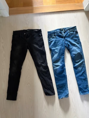 Två par slim fit jeans från replay - Säljer två snygga Replay jeans i storlek W29 / L32. Ett par i klassisk blå denim och ett par i svart. Båda i fint skick med normal användning och skön passform.  * Märke: Replay * Storlek: 29 Waist / 32 Length * Färg: Blå & Svart * Skick: Bra skick * Slim/regular passform med stretchig och bekväm känsla  Perfekta till både vardag och lite mer uppklätt. Säljes tillsammans eller separat. 400 för ett par eller båda för 650!