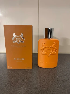 Parfums de Marly Althair EdP 125ml - Exklusiv parfym från Parfums de Marly, Althair EdP, i en snygg orange flaska med silverfärgat lock. Flaskan har ett elegant reliefmönster med två hästar och sköld. Kommer i matchande orange kartong. Volym: 125 ml. Pris kan diskuteras vid snabb affär! Endast sprayat 1-3 spray var inte riktigt min typ av parfym 