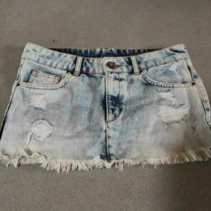 jeanskjol - Trendig ljusblå jeanskjol med slitna detaljer. 