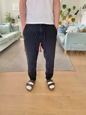 Mörkblå Linnebyxor Selected Homme - Snygga mörkblå linnebyxor med avslappnad passform. Perfekta till sommarenför en chill och stilren look.