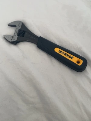  skiftnyckel Ironside - En svart och gul justerbar skiftnyckel från Ironside med greppvänligt handtag i plast och metallhuvud. Perfekt för att lossa eller dra åt muttrar och bultar i olika storlekar. Praktiskt verktyg att ha hemma eller i verktygslådan. Aldrig använd 