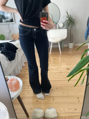 Mörkblå ultra low flare jeans från Gina tricot - Snygga mörkblå bootcut jeans med kontrasterande vita sömmar. Från Gina tricot använd några gånger men i fint skick (inga tecken på användning) 🌸