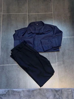Svart kostymbyxa & marinblå skjorta - Fetsnygg färdig matchande stil kostymbyxa (Jack & Jones) storlek 33/32. Marinblå skjorta (SHEIN) storlek M. Oanvända