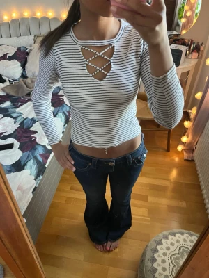 Randig croppad långärmad topp - Snygg vit och svart randig croppad topp med lång ärm och unik snörningsdetalj framtill