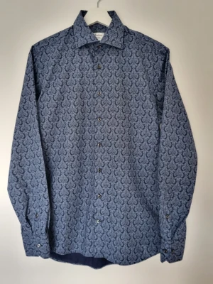 Stenströms Skjorta Stl 40 - Säljer en blå skjorta från Stenströms med ett elegant blommigt mönster. Den är I mycket bra skick och har inga tecken på användning. Kragomkretsen är 40 cm, vilket motsvarar ungefär en medium/small. Hör av dig om du har fler frågor så svarar jag gladeligen:)