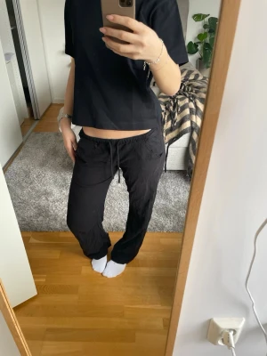 Svarta linne byxor  med dragsko - Säljer ett par svarta linne byxor  med avslappnad passform och dragsko i midjan. Byxorna har raka ben och är tillverkade i ett mjukt, tunt linne material. Enkla att matcha med en t-shirt eller hoodie. Byxorna är från Nelly och är omsydda av mig. Så fickorna är dit sydda. 