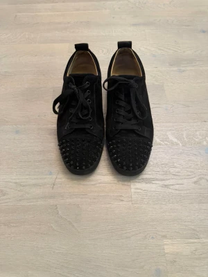 Svarta sneakers med nitar från Louboutin - Svarta klassiska Christian Louboutin. Säljer pga använder inte dem, finns bevis på chattar och äktenhet där jag köpte dem ifrån. Inget og medföljer!! Obs 1 spik saknas på framsidan som knappt syns