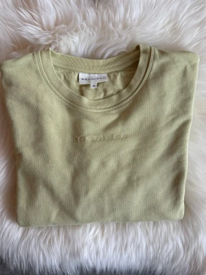 Ljusgul sweatshirt från Röhnisch - •En stilren ljusgrön sweatshirt från Röhnisch med  en diskret logotyp broderad framtill på bröstet. •Tröjan har rund halsringning och är tillverkad i mjuk bomull.  •Perfekt för en avslappnad och trendig look. •Knappt använd, som ny. Tvättad.  🚭Djurfritt och rökfritt hem 🌸Se gärna mina andra annonser för samfrakt ✨Har bundle-rabatt