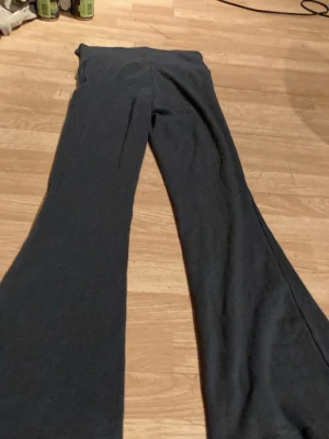 Svarta utsvängda leggings - Säljer ett par svarta leggings med utsvängda ben. De har hög midja och är gjorda i ett mjukt stretchigt material som sitter skönt på kroppen. Perfekta för dig som gillar en avslappnad men trendig stil.