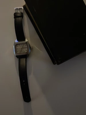 70-tals Schweizisk klocka Monvis - Säljer min fina vintage Monvis Automatic från 1970-talet. Schweizisk klocka i rostfritt stål med charmig cushion boett! Viktigt att tänka på! Klockans timm/minut visare funkar ej, ett kugghjul är löst men det går att fixa! Automatisk 25 rubis med Incabloc och vit urtavla. Genuin schweizisk vintage. Just denna modell är extremt svår att hitta eftersom denna  modellen med cushion boett (fyrkantig) gjordes inte så många av. Bortsett ifrån defekterna är klockan en extremt snygg statement piece för 🫵