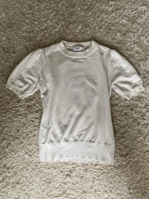 Vit topp från Saint Tropez - Klassisk vit topp från Saint Tropez med rund halsringning och korta puffärmar. Tillverkad i mjukt material som ger en bekväm passform.