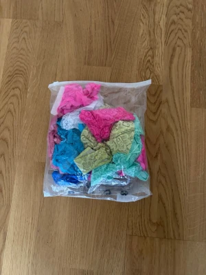 Färgglada spets-trosor i mixpack 100kr - Säljer ett mixpack med flera par trosor i olika färger som rosa, blå, grön, gul och vit. Trosorna är i spetsmaterial och har en feminin och ungdomlig design. Perfekt för dig som gillar variation och färg i underklädeslådan. Självklart helt oanvända.