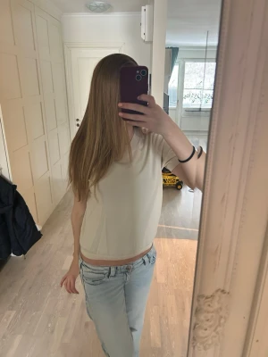 Beige croppad topp i bomull - Säljer en enkel och stilren beige croppad topp i mjuk bomull. Toppen är ärmlös och har en rund halsringning, perfekt att matcha med jeans eller kjol. Passformen är normal och toppen är lätt att bära till olika outfits.