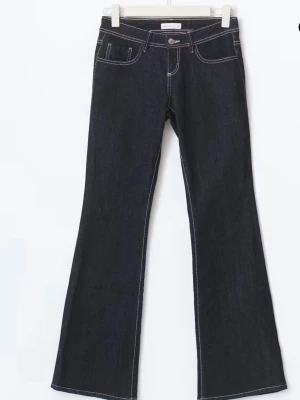 Ultra low bootcut jeans Ginatricot - Ultra lowaist jeans från ginatricot. Jeansen är mörkblåa med vita sömmar och är väldigt populära. De är nästan helt oanvända och är i storlek 32. 