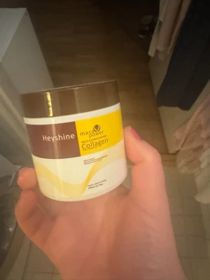 Heyshine Collagen Maca Power - Kollagenpulver från Heyshine med macaextrakt, perfekt för dig som vill boosta din skönhetsrutin. Burken är vit med brunt lock och har gula detaljer. Innehåller 200g pulver som blandas i dryck eller smoothie.
