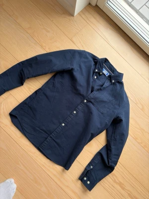 Mörkblå skjorta Jack & Jones  - Säljer en tvär fet skjorta från Jack & Jones. Perfekt för middagar och speciella kvällar och event. Storlek xs. Vid fler frågor och funderingar är det bara att höra av sig