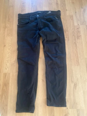 Svarta slim fit jeans från Replay - Svarta jeans från Replay i slim fit-modell med klassisk femficksdesign. Jeansen har normal midja och är tillverkade i ett stretchigt denimtyg för extra komfort. Perfekta för en stilren och avslappnad look.