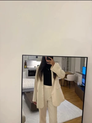 Beige kavaj  - Stilren beige kavaj. Kavajen har klassisk passform, långa ärmar och knappar framtill. Perfekt för dig som gillar en clean och modern look. Bär med en svart topp för kontrast. Lite oversize i modellen. Finns matchande byxor att köpa separat om man önskar de.