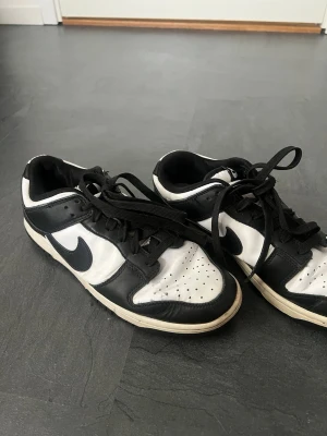 Nike Dunk Low svart/vit sneakers - Snygga Nike Dunk Low sneakers i svart och vitt läder använda 1 år väll omhändertagande. Snabbare affär= bättre pris skriv vid minsta fråga eller fundering 