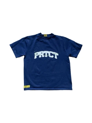 ProtectLdn T-shirt - Snygg blå t-shirt från ProtectLdn med vit text på bröstet och liten logga i nacken. Klassisk passform med korta ärmar och rund hals. Perfekt för en avslappnad och cool stil. Materialet känns mjukt och bekvämt. Passa på att fråga om bild eller mått om det behövs! ⭐️