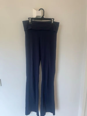 Mörkblå yoga pants från Gina Tricot - Mörkblå mjukisbyxor från Gina Tricot med utsvängda ben och hög midja. Byxorna är gjorda i ett mjukt och stretchigt material som känns skönt mot huden. Perfekta för en avslappnad och chill stil.