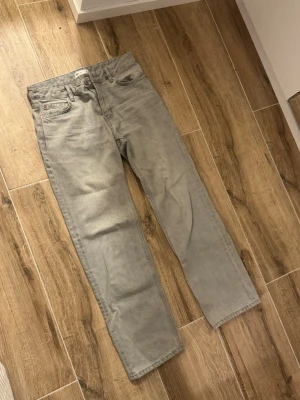 Grå raka jeans från Gina tricot  - Snygga grå jeans från Gina tricot med rak passform och klassisk femficksdesign. Jeansen har en stilren look och är tillverkade i denim. Perfekta för dig som gillar en clean och avslappnad stil.