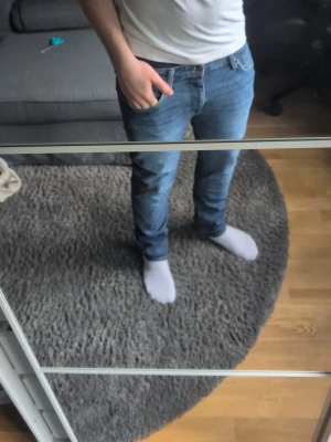 Blå slim fit jeans herr - Säljer ett par blå slim fit jeans med klassisk femficksdesign och normal midja. Jeansen har en snygg tvätt och sitter tajt längs benen för en modern look. Perfekta till vardags och passar till det mesta i garderoben.