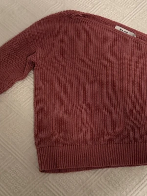 Rosa stickad tröja från NA-KD - Mysig stickad tröja i mörk rosa från NA-KD. Tröjan har rund halsringning, långa ärmar och bred ribbstickad mudd vid ärmslut och nederkant. Perfekt för lager på lager och enkel att matcha med jeans eller kjol🥰
