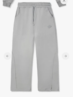 Gråa mjukisbyxor från Represent - Helt nya prislappen på.Snygga grå mjukisbyxor från Represent med raka ben, dragsko i midjan och sidofickor. Byxorna har en diskret logga på låret och är tillverkade i mjukt bomullsmaterial för maximal komfort.