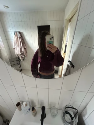 Vinröd croppad långärmad topp - Snygg vinröd croppad topp med långa ärmar och rund halsringning. Enkel och stilren design som passar perfekt till jeans eller kjol. Mjuk och skön, perfekt för dig som gillar en avslappnad men trendig look.