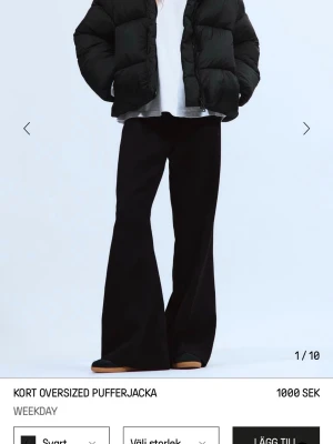 Svart oversized pufferjacka Weekday - Kort oversized pufferjacka i svart från Weekday. Jackan har en boxig passform, breda kanaler och hög krage. Perfekt för kalla dagar och ger en cool, avslappnad look. Tillverkad i syntetmaterial med fyllning som håller värmen.