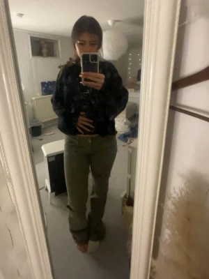 Gröna raka jeans med hål vid knät - Snygga gröna jeans med rak passform och ett stort slitet hål vid ena knät. Jeansen har klassisk femficksdesign och normal midja. Perfekta för en avslappnad och trendig stil.