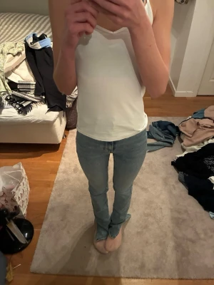 Ljusblå skinny jeans med slits - Säljer ett par ljusblå smala utsvängda jeans med slits nertill vid bensluten. Jeansen har klassisk femficksdesign och är i stretchigt denimtyg som sitter tight hela vägen ner. Perfekta för en trendig och avslappnad look.