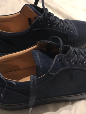 Mörkblå Louboutin  - Snygga mörkblå sneakers i mocka med klassisk låg profil och matchande mörkblå snören. Har använt den ganska mycket och priset går det diskuteras….😀