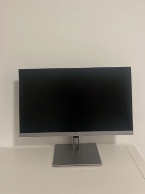 HP bredbilds datorskärm silver - Stilren HP datorskärm med bredbildsformat och tunn ram. Skärmen har en modern, rektangulär design i silverfärgat metallmaterial och står på en stabil fot. Perfekt för gaming, film eller studier och passar snyggt på skrivbordet.