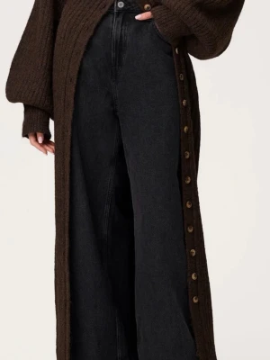 Mörkbrun stickad långklänning - Montana Maxi Dress i brunt från Adoore! Stickad fantastisk klänning med ribbad struktur och knappar längs hela framsidan. Klänningen har långa, voluminösa ärmar och en slits nedtill för extra rörelsefrihet. Perfekt för dig som gillar en avslappnad men ändå stilren look.