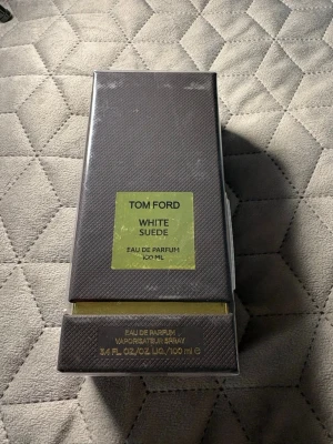 Tom Ford White Suede EdP 100 ml - Tom Ford White Suede Eau de Parfum 100 ml i elegant mörkbrun förpackning med guldfärgade detaljer. Lyxig doft som kombinerar mjuka och sensuella toner, perfekt för dig som gillar exklusiva parfymer. Snygg och stilren design som känns exklusiv.